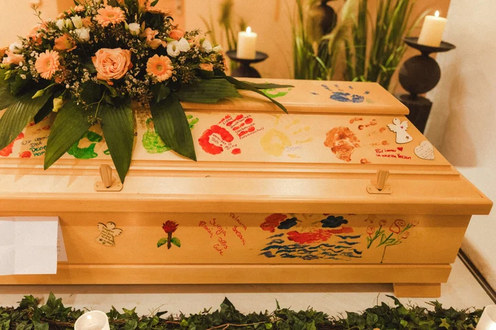 Mit Blumen geschmückter und bemalter Sarg