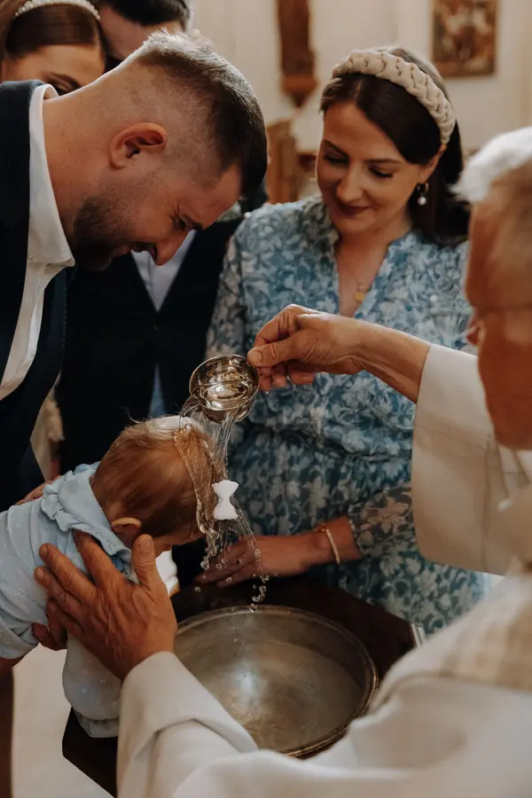 Taufe von einem Kind am Taufbecken