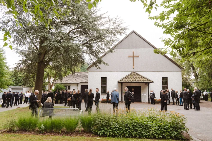 Trauergemeinde vor einer Kapelle